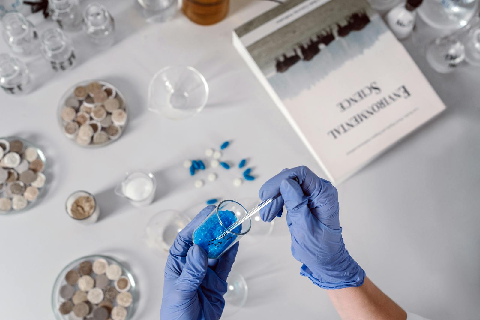 Person Holding a Glass Tube and Dropper with Chemicals